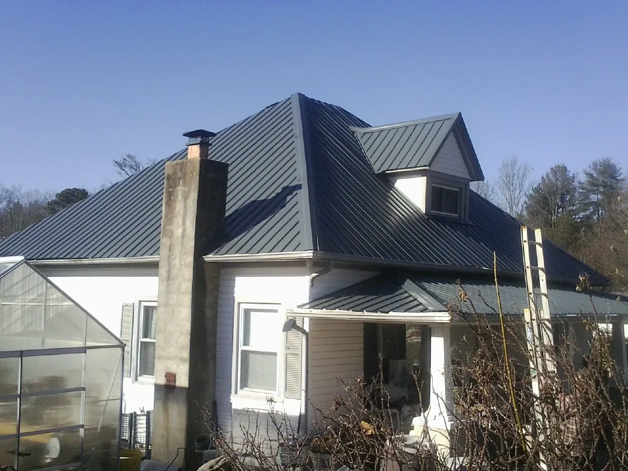 Dark blue standing seam metal roof on a white farmhouse with dormer — Slate & Tile Roof Repair by Roofing Brothers in Satsop