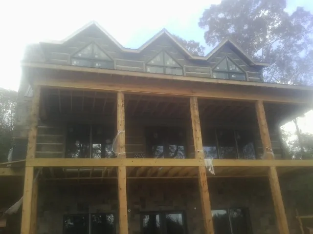 Dormers and porch framing on a large log home under construction — Roof Coating work by our crew in Satsop
